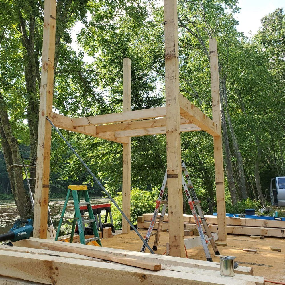 A wooden structure is being built with a ladder in the foreground