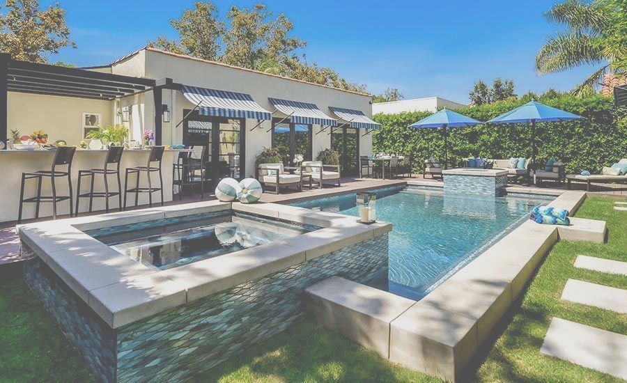 There is a large swimming pool in the backyard of a house.