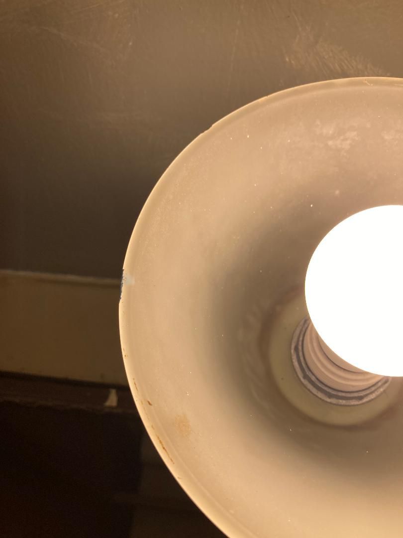 Close-up of a lit lamp with a beige shade against a dark background