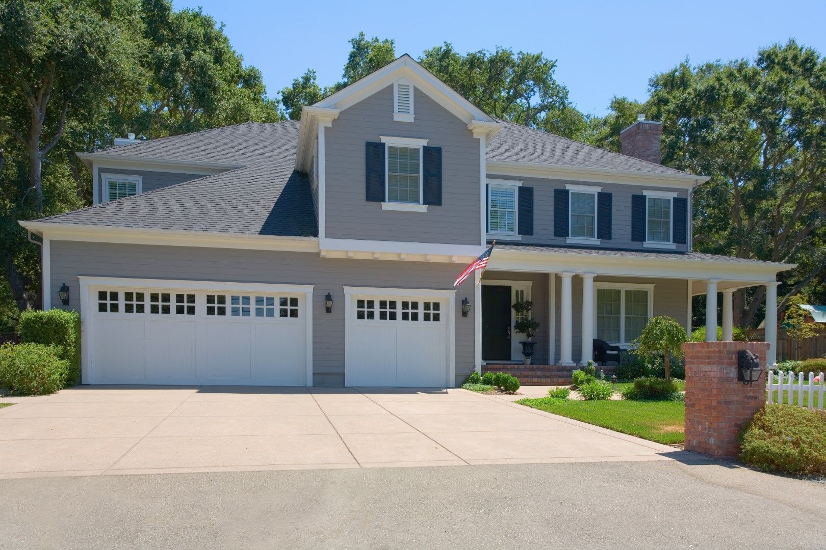 A large house with two garage doors and a porch