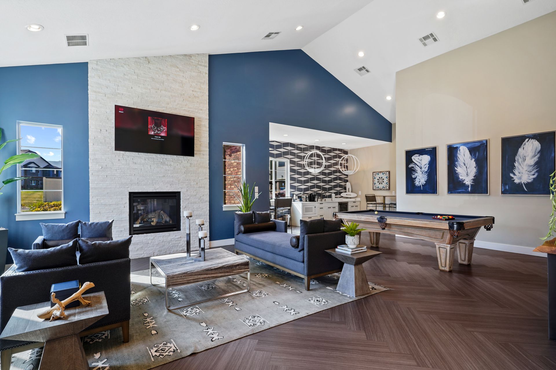 Modern lounge area with fireplace, pool table, and blue accent wall at Wilshire Place, featuring apartments in West Jordan, UT.