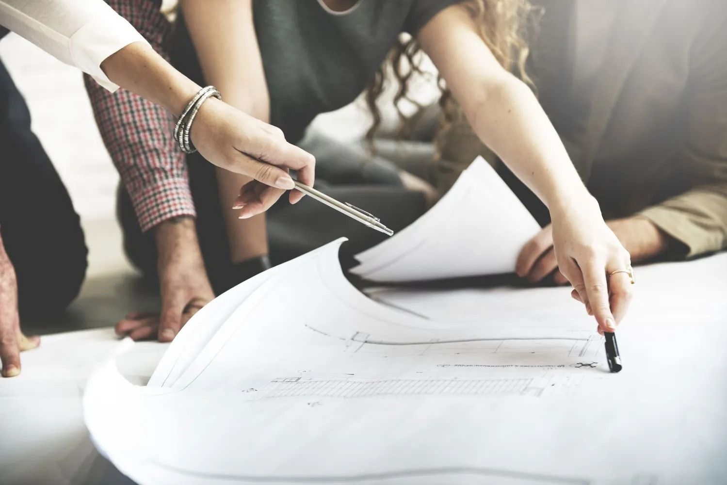 A group of people are looking at a blueprint together.