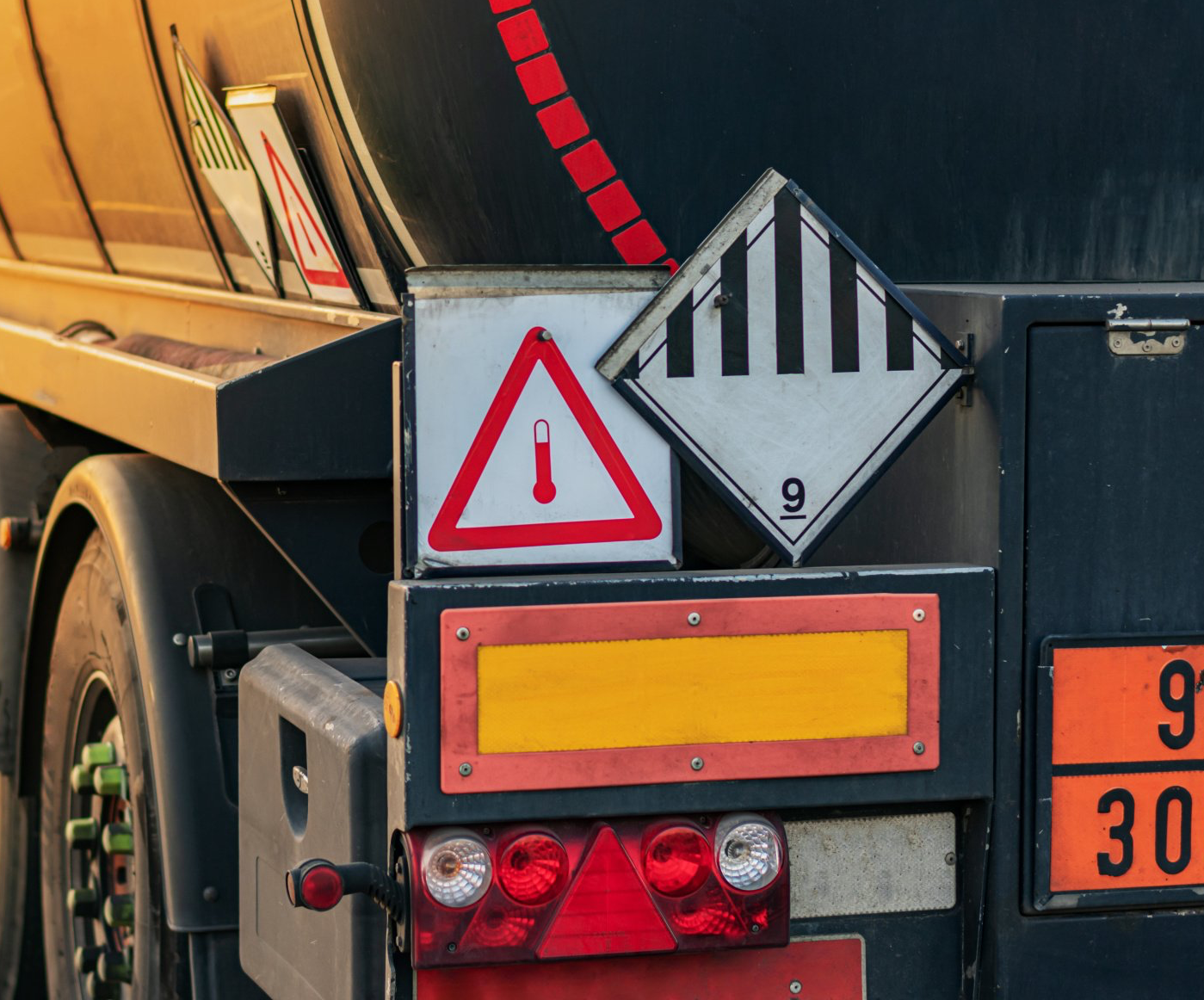 Heck eines Tanklastzugs mit orangefarbener Gefahrguttafel und rotem Gefahrzettel für entzündbare flüssige Stoffe