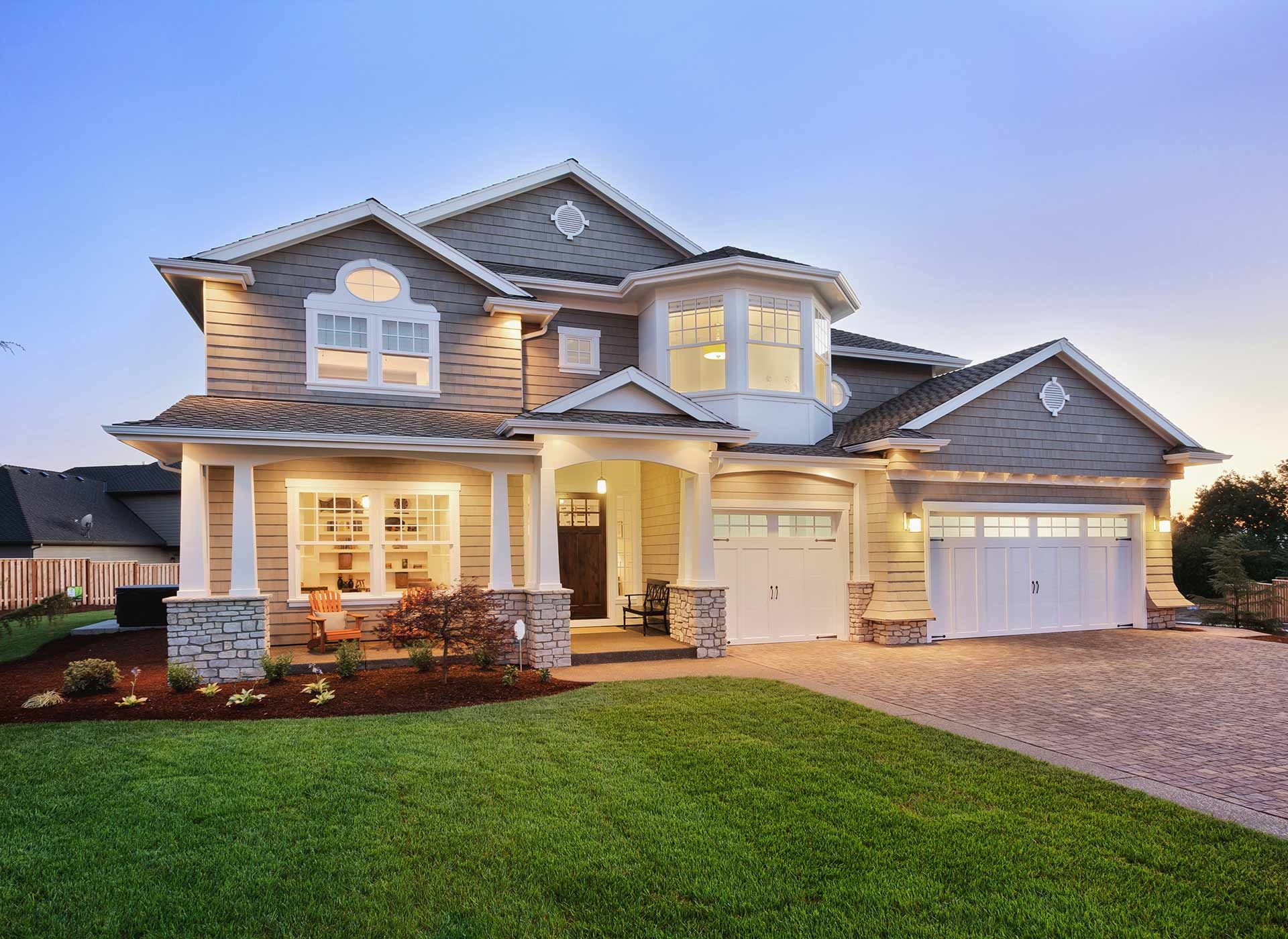 Two-story house with gray siding, white trim, and a green lawn.