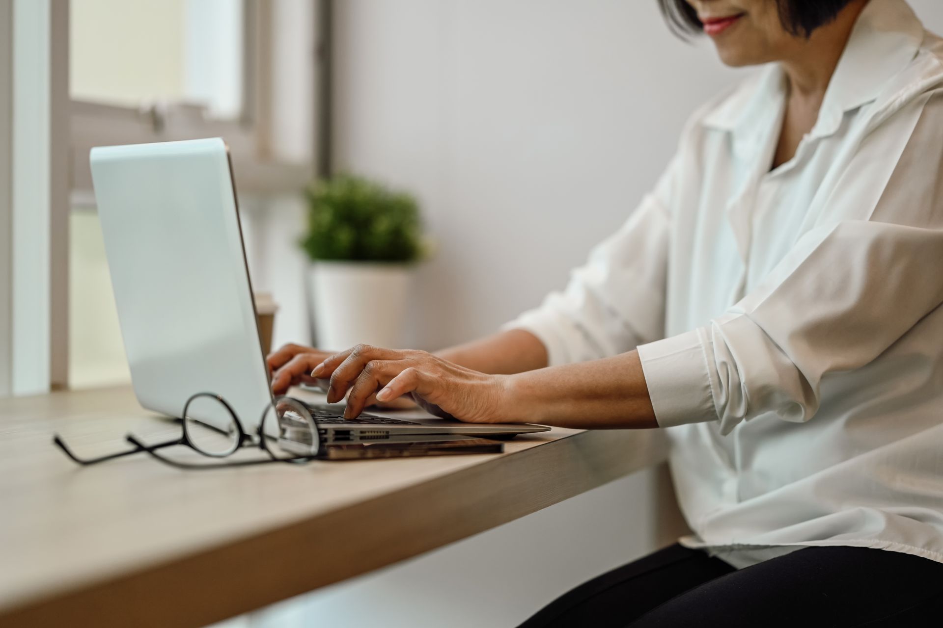 Hands typing on a laptop with a transparent checklist interface overlay on the screen