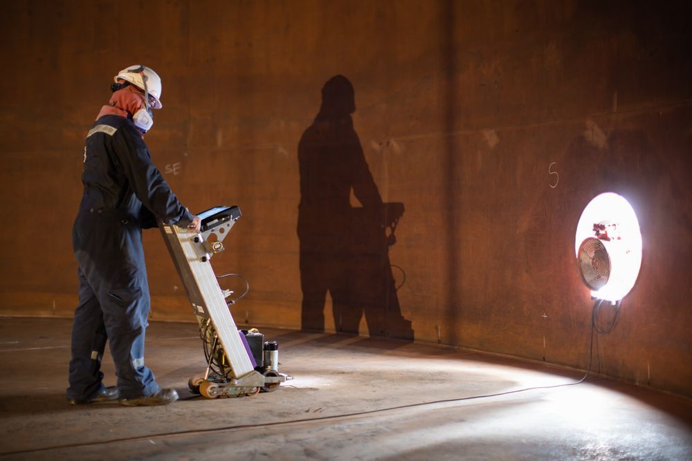Person in Protective Gear Operating a Floor Grinder — Phoenix Protective & Marine Coating Specialists in Torres Strait, QLD