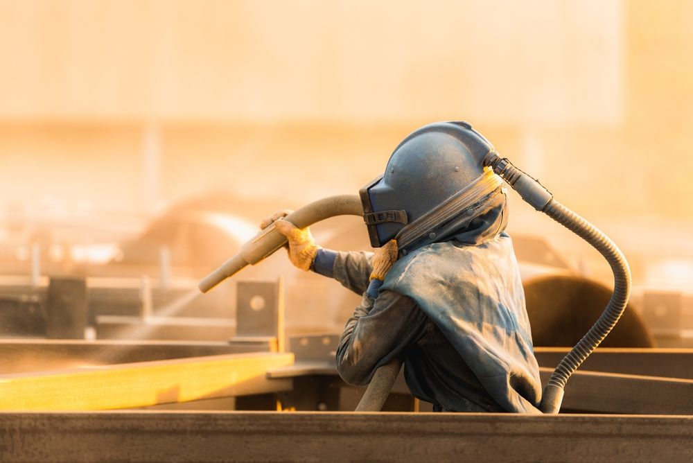Person in Protective Suit Sandblasting — Phoenix Protective & Marine Coating Specialists in Torres Strait, QLD