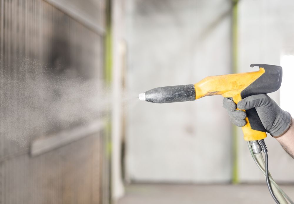 Person in Gloves Applying Powder Coating — Phoenix Protective & Marine Coating Specialists in Torres Strait, QLD