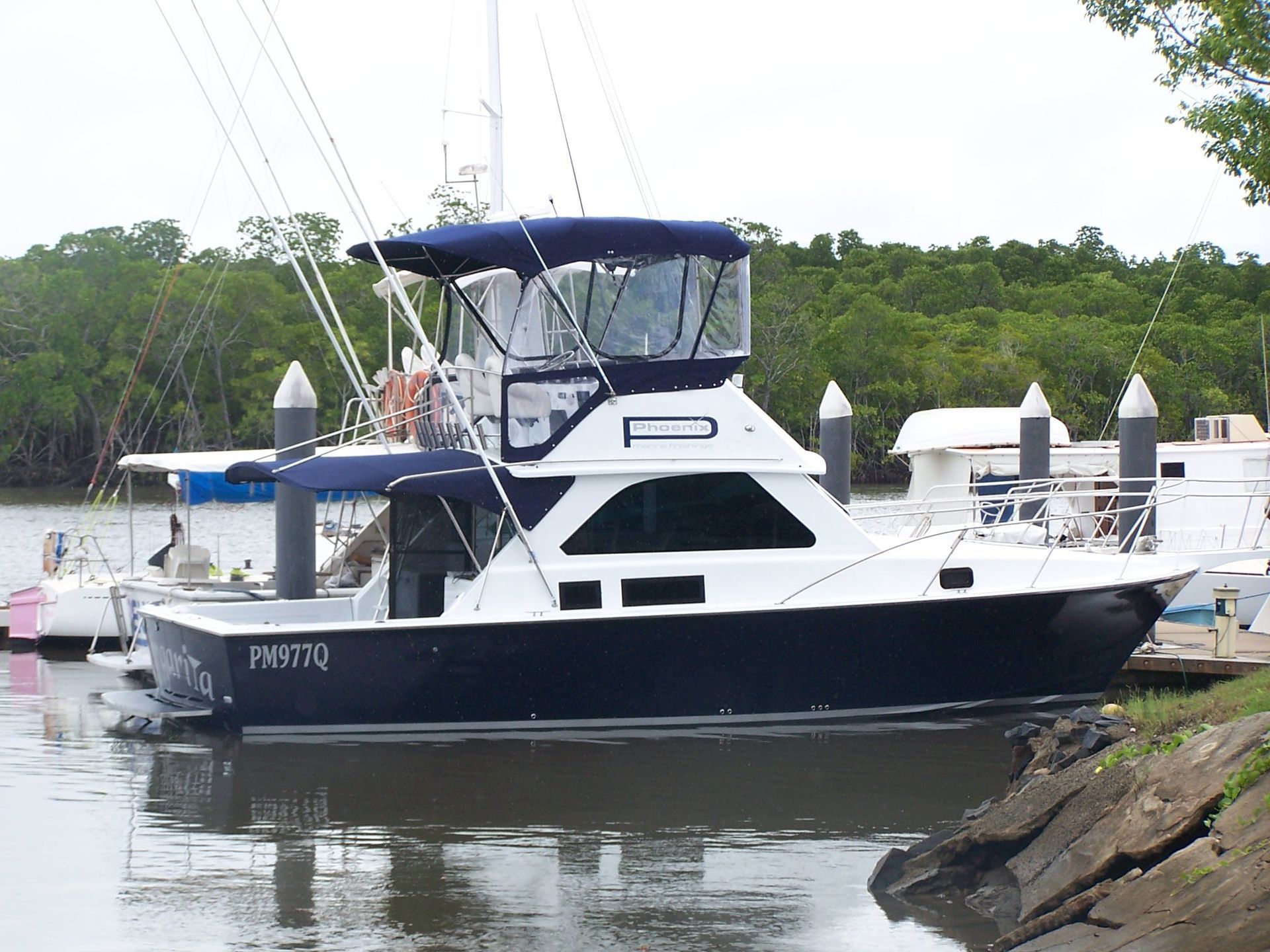 White-and-navy Fishing Boat Docked on Calm Water — Phoenix Protective & Marine Coating Specialists in Woree, QLD