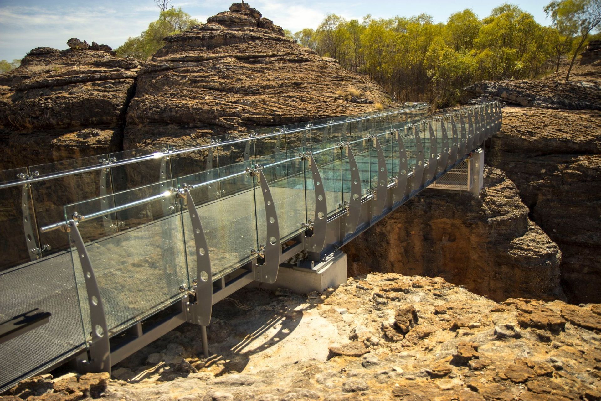 Glass Pedestrian Bridge Spanning a Rocky Canyon — Phoenix Protective & Marine Coating Specialists in Woree, QLD