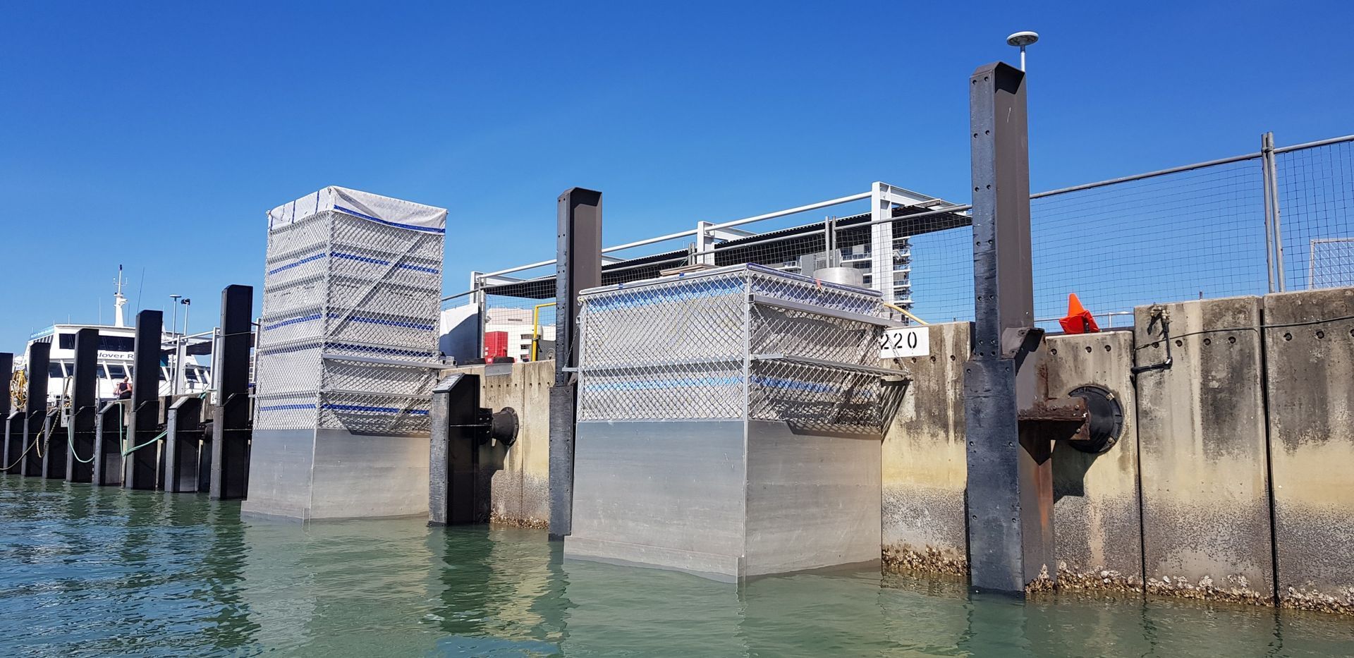 Dockside Marina Gate with Metal Barriers and Calm Blue Water — Phoenix Protective & Marine Coating Specialists in Woree, QLD