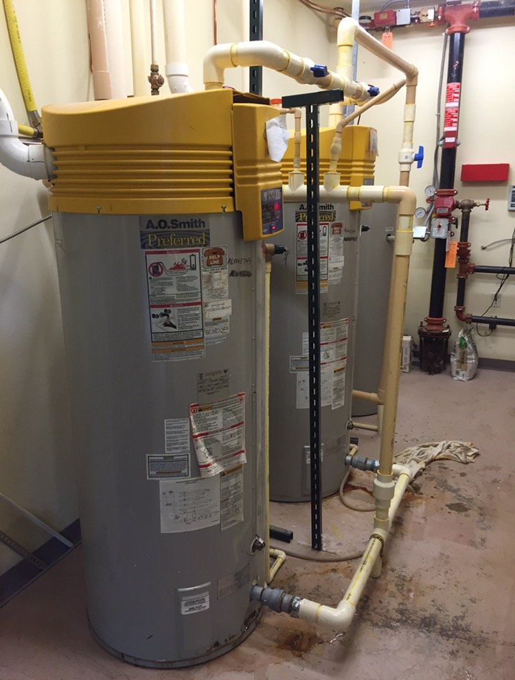 A bunch of water heaters are lined up in a room