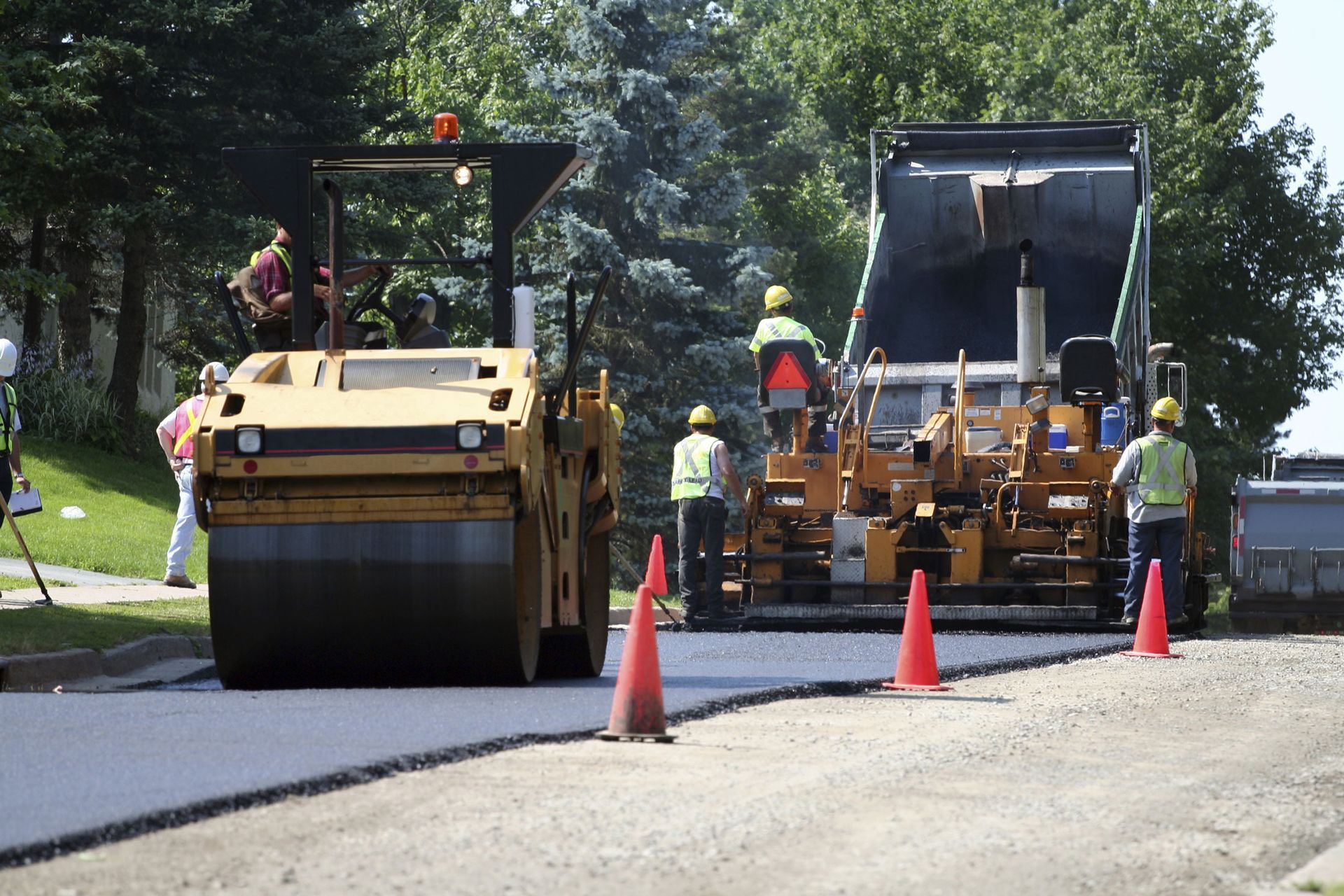 An asphalt spreader is used to place the first layer of asphalt on a city street renewal project