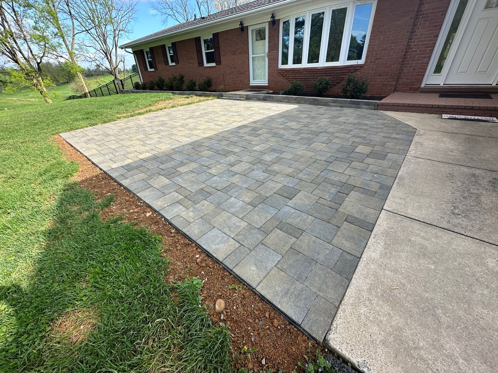 A brick house with a patio in front of it.