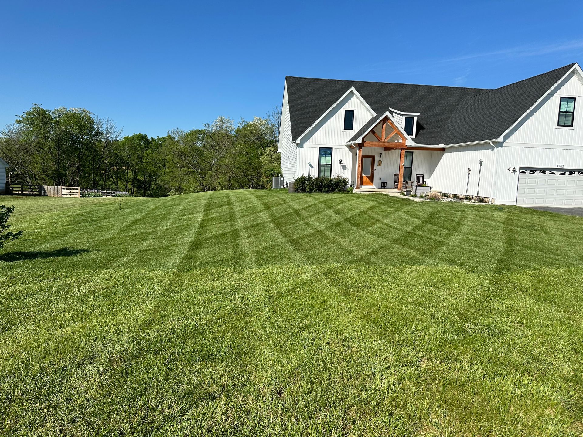 A large white house with a lush green lawn in front of it.