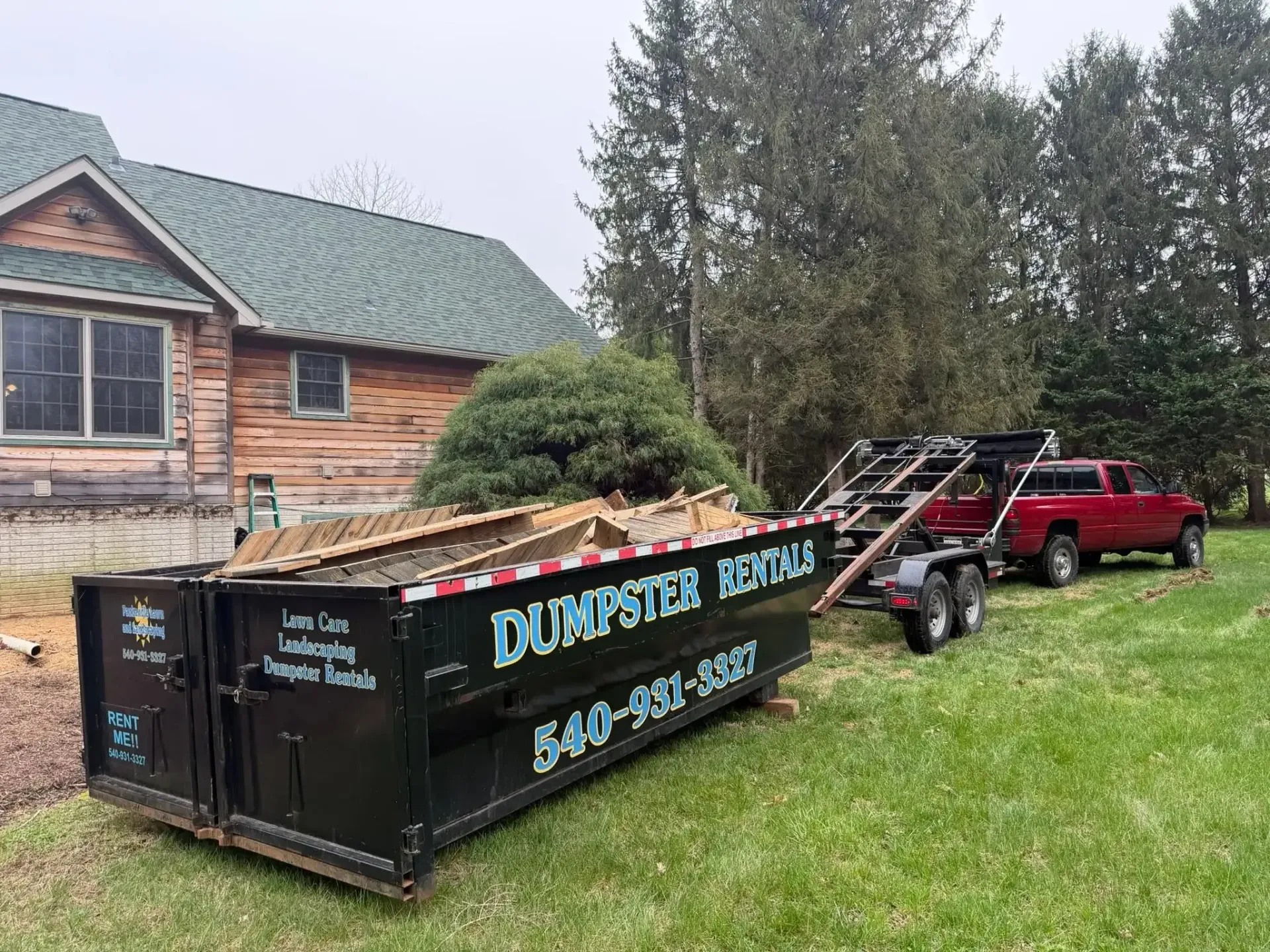 Roll-off dumpster rental loaded with wood debris beside a Charles Town, WV home Roll-off dumpster rental loaded with wood debris beside a Charles Town, WV home