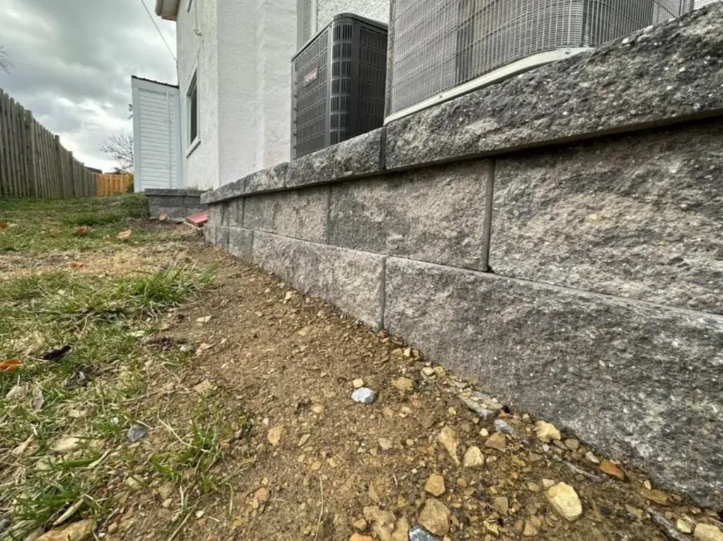 A brick wall is being built on the side of a house.