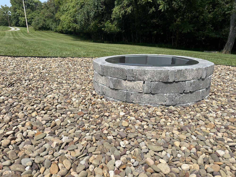 A fire pit is sitting on top of a pile of gravel.