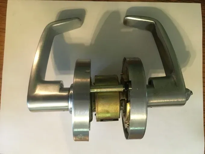 A silver commercial-style door lever set with a cylindrical latch mechanism shown against a white background.