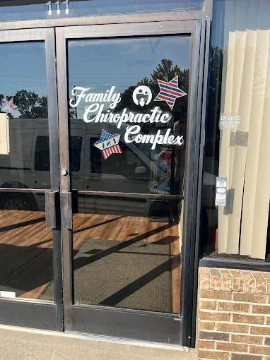 Glass front door of Family Chiropractic Complex, featuring star-shaped decals with red, white, and blue patterns.