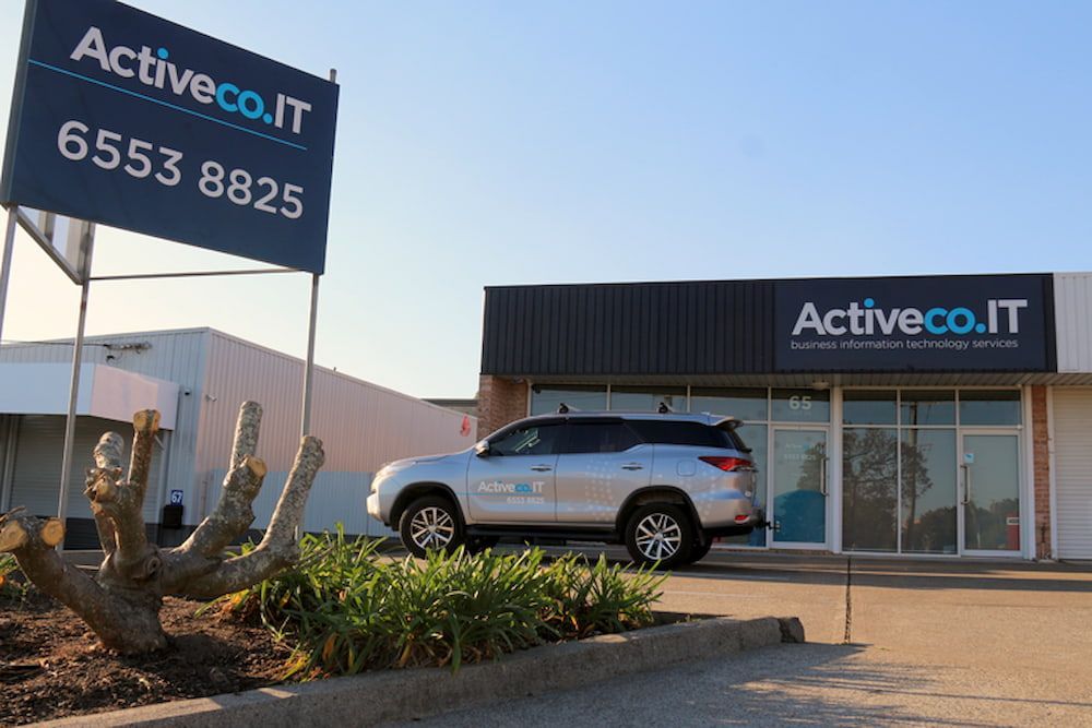 A White Suv Is Parked In Front Of A Building  — ActiveCo.IT in Taree, NSW