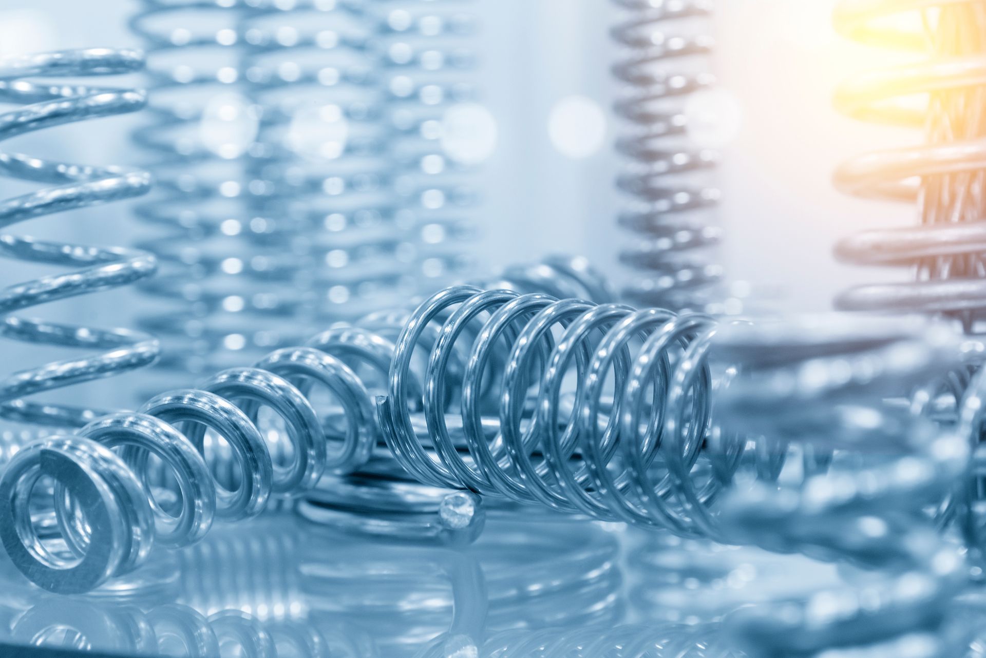 High-quality compression spring supplier parts, close-up on a bright factory floor. High-quality compression spring supplier parts, close-up on a bright factory floor.