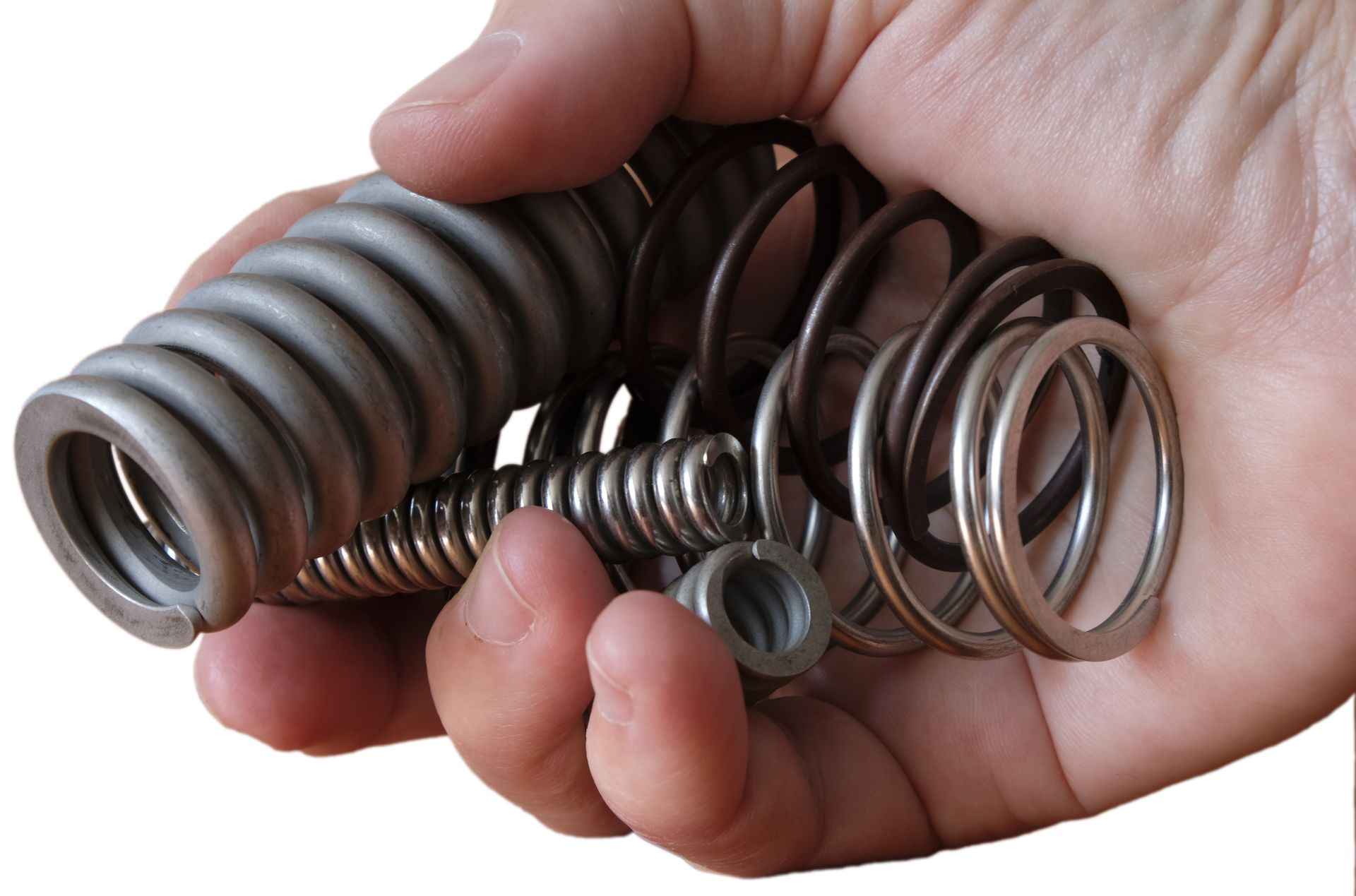 Hand holding a collection of metal springs and small hardware parts. 
