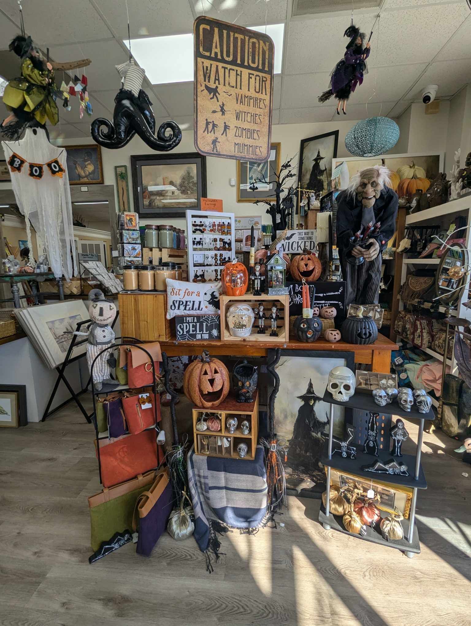 Halloween-themed shop display with pumpkins, skulls, and signs.