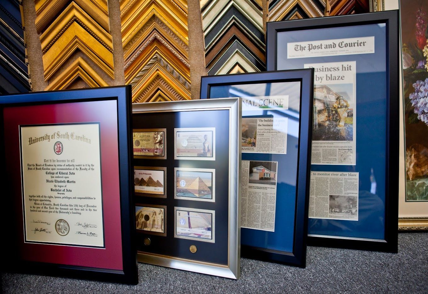 Framed documents and photographs, various sizes, with colorful mats. Frame samples in the background.