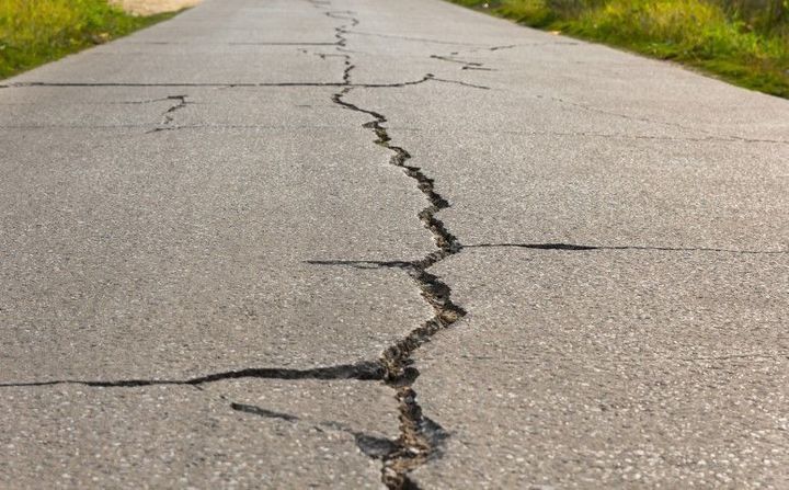 Cracked asphalt road with a long central fissure