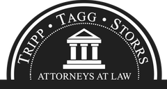 Black law firm logo reading “TIRRIP TAGG STORRS ATTORNEYS AT LAW” with courthouse icon on circular seal