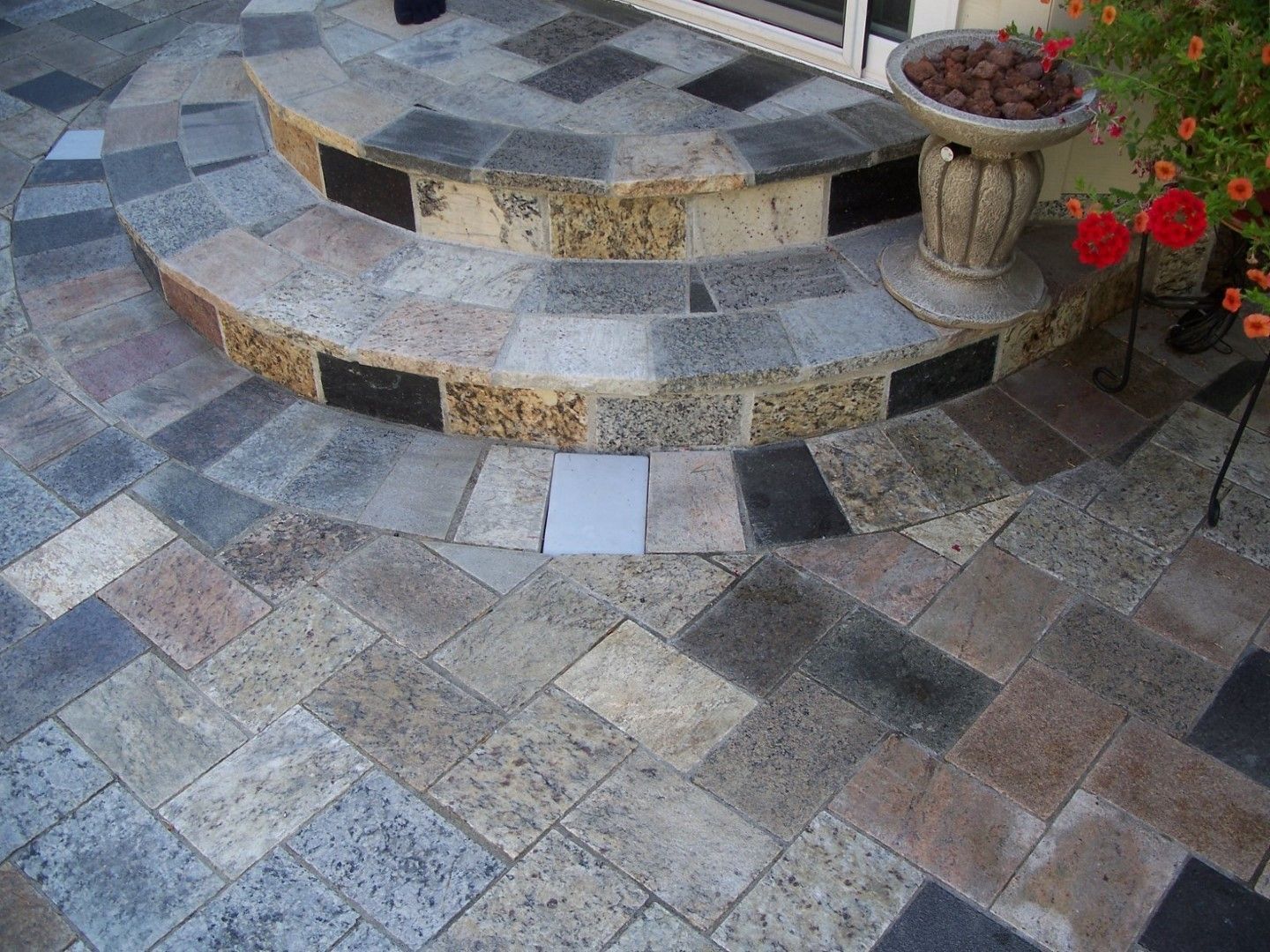 A stone patio with steps and a potted plant