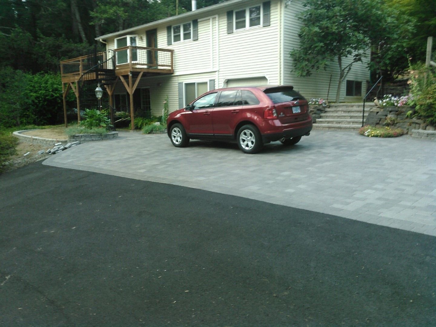 A red car is parked in front of a house