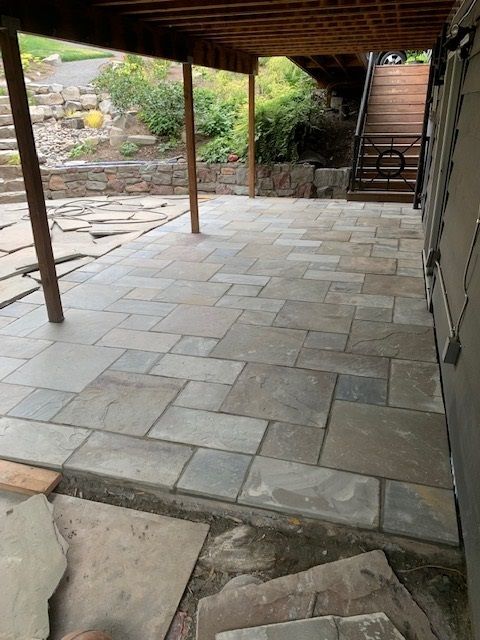 A patio with a wooden roof and stairs in the background