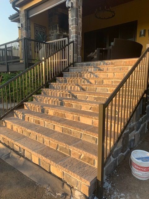 A set of stairs leading up to a porch with a metal railing