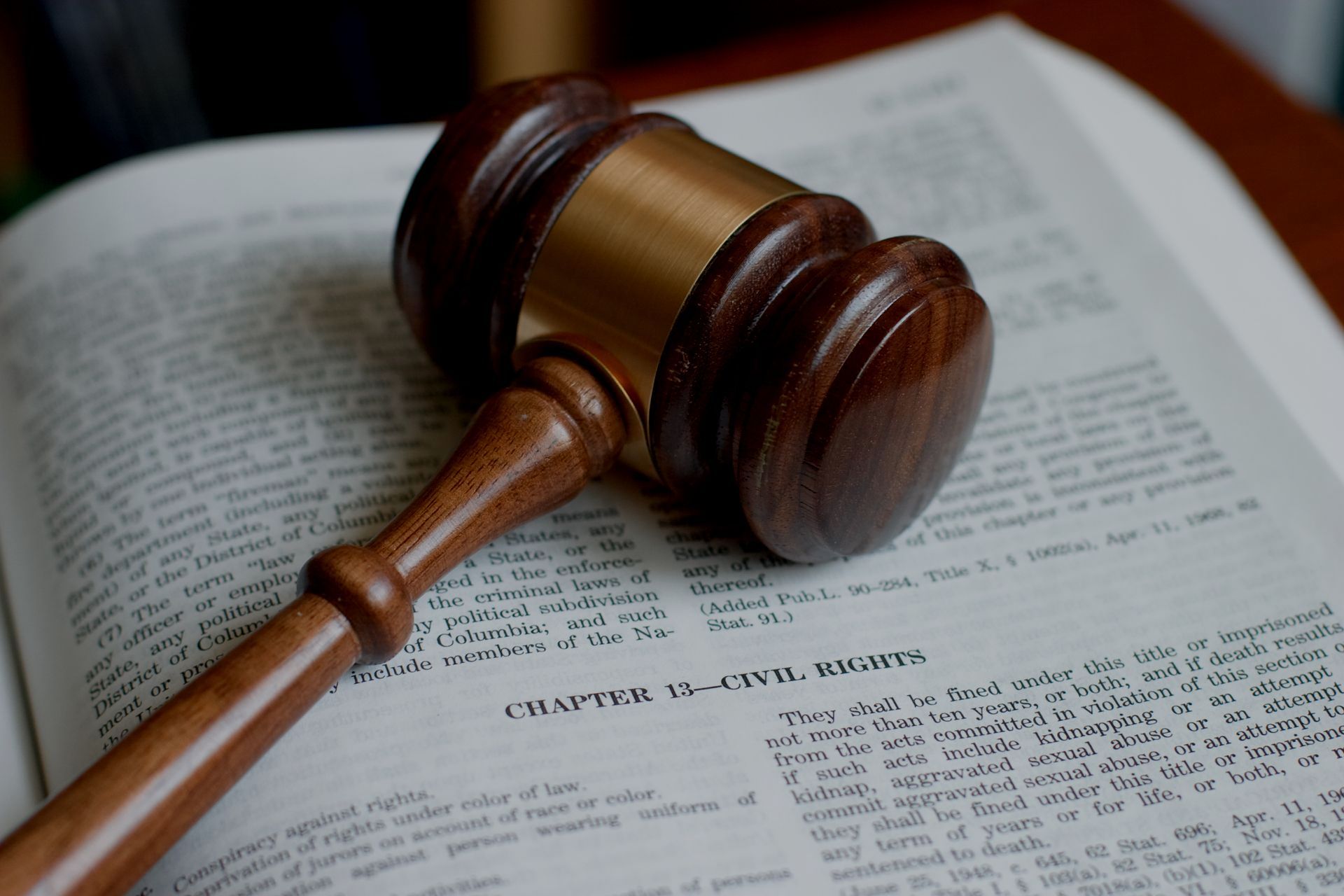 Wooden gavel on top of an open law book.