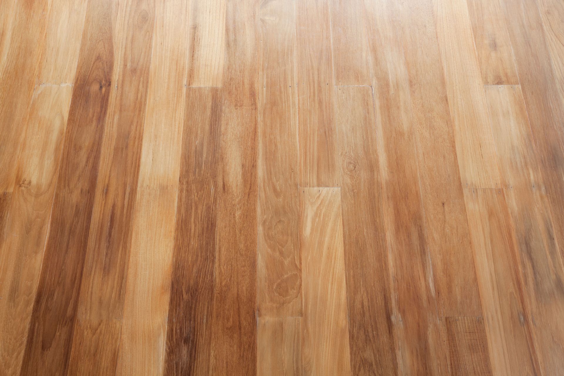 Close-up view of light and medium-toned wood flooring planks with visible grain patterns.