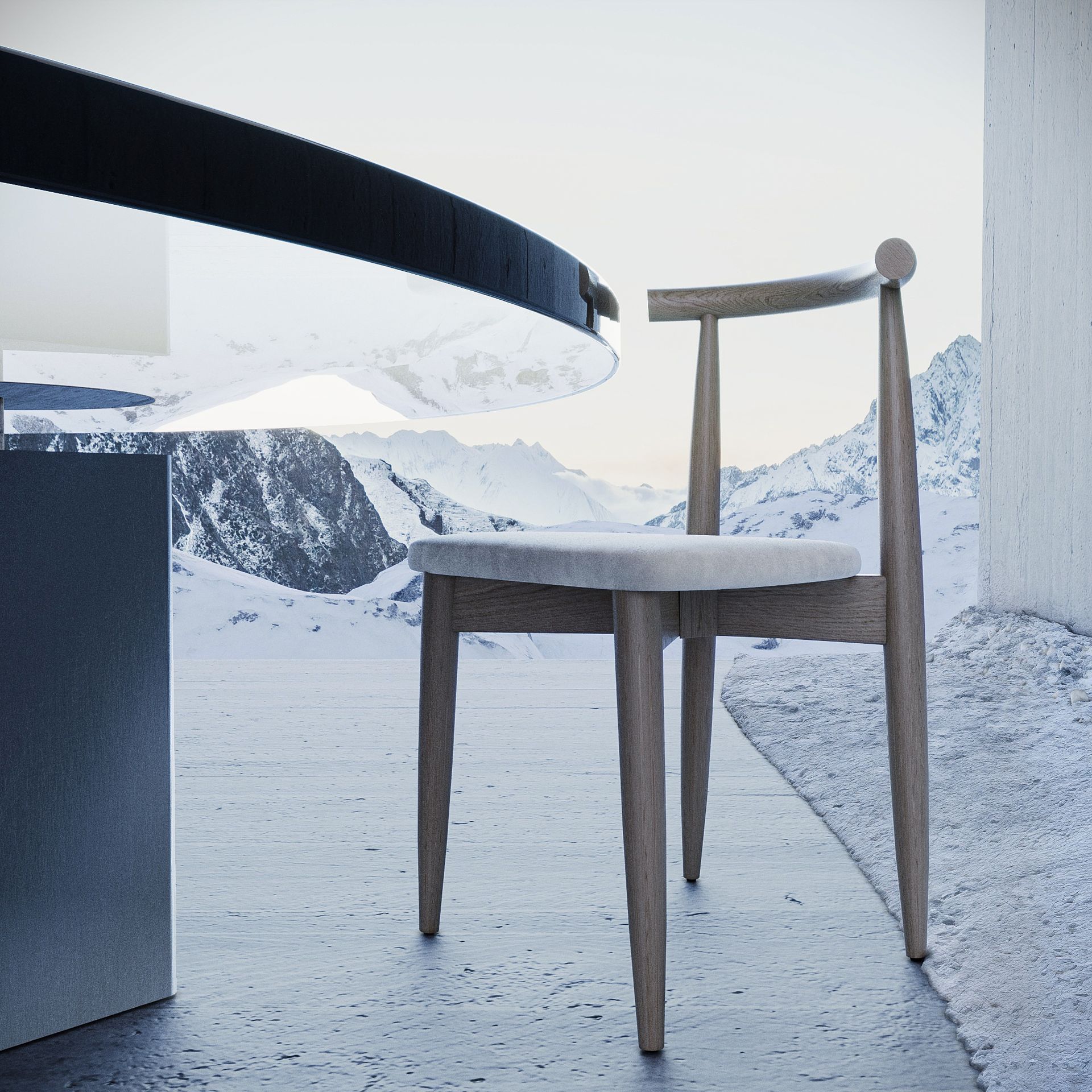 Uma cadeira de madeira clara fica em um pátio nevado ao lado de uma mesa escura, com uma cadeia de montanhas ao fundo.