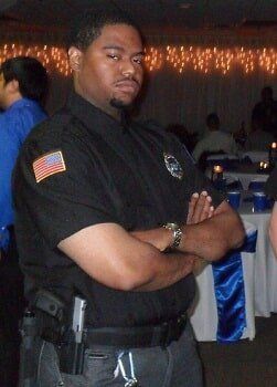 A man in a black uniform with an american flag on his shoulder