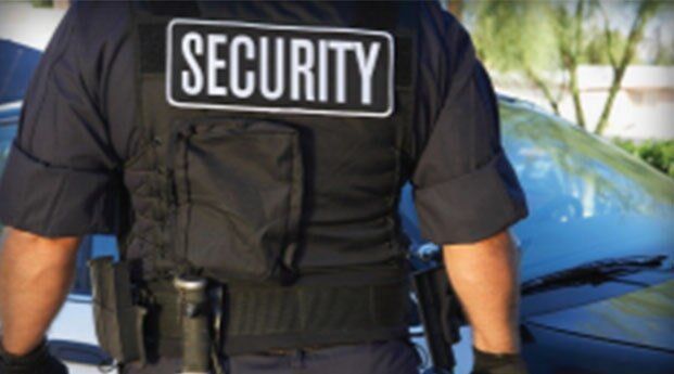 A security guard standing in front of a car