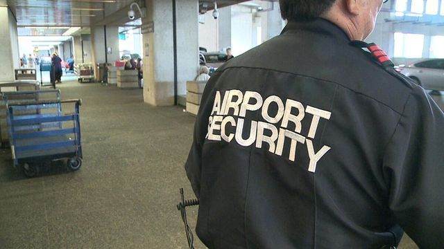A man is wearing an airport security jacket