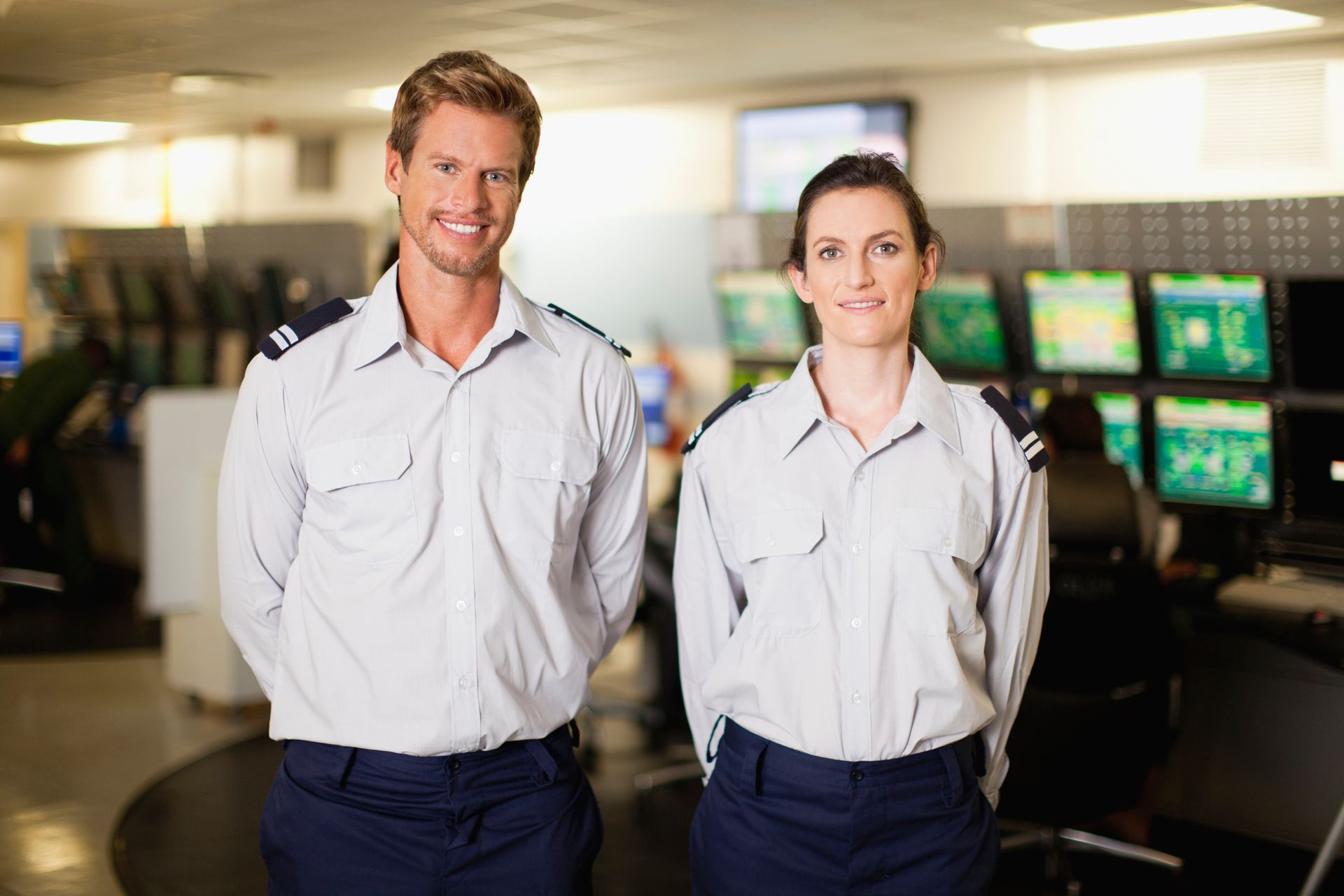 A man and a woman are standing next to each other in a control room. A man and a woman are standing next to each other in a control room.