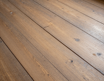 Primo piano di assi di legno invecchiate, con venature e nodi ben visibili