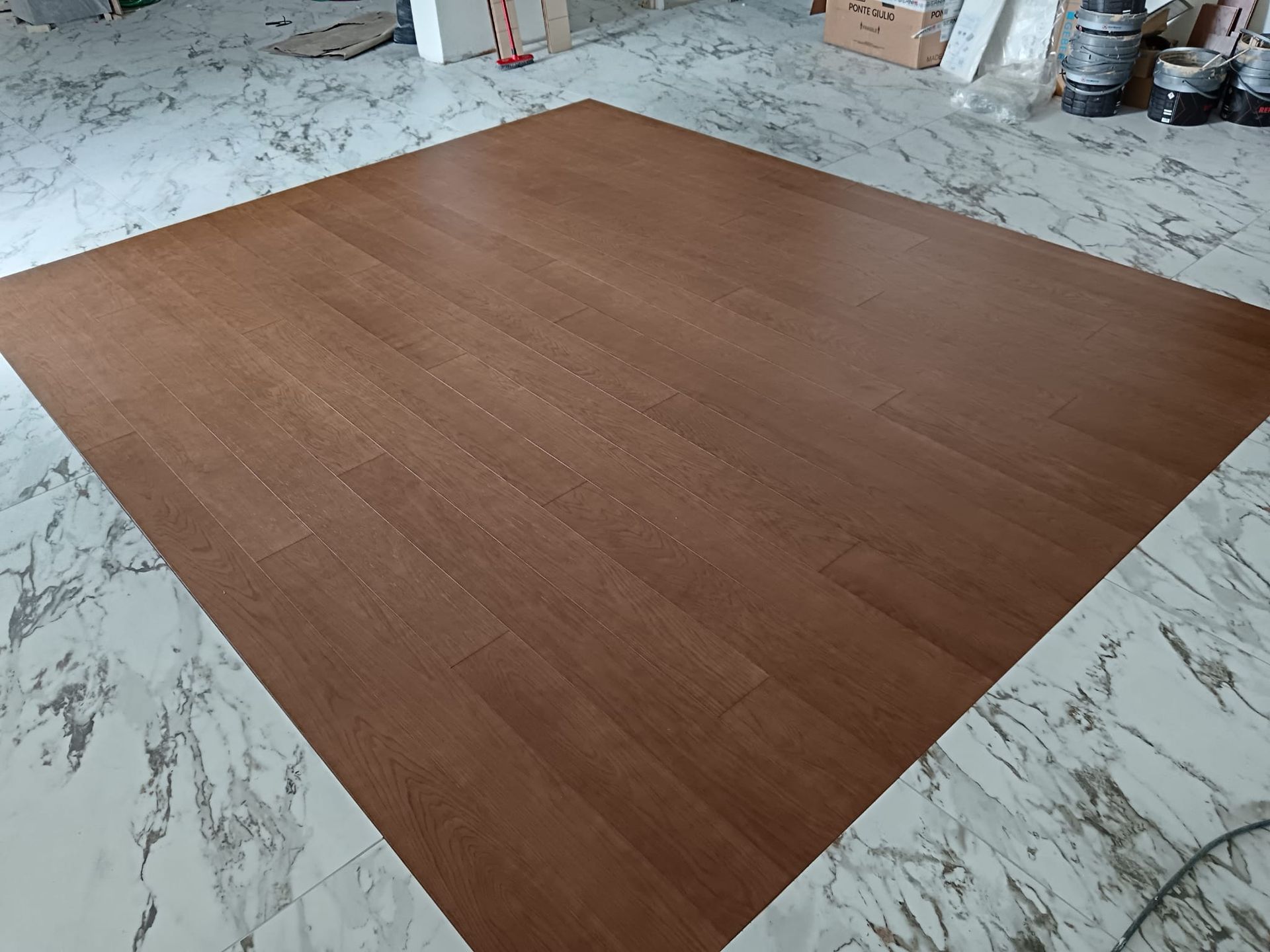 Grande tavola di legno marrone appoggiata su un pavimento di marmo chiaro in un laboratorio.