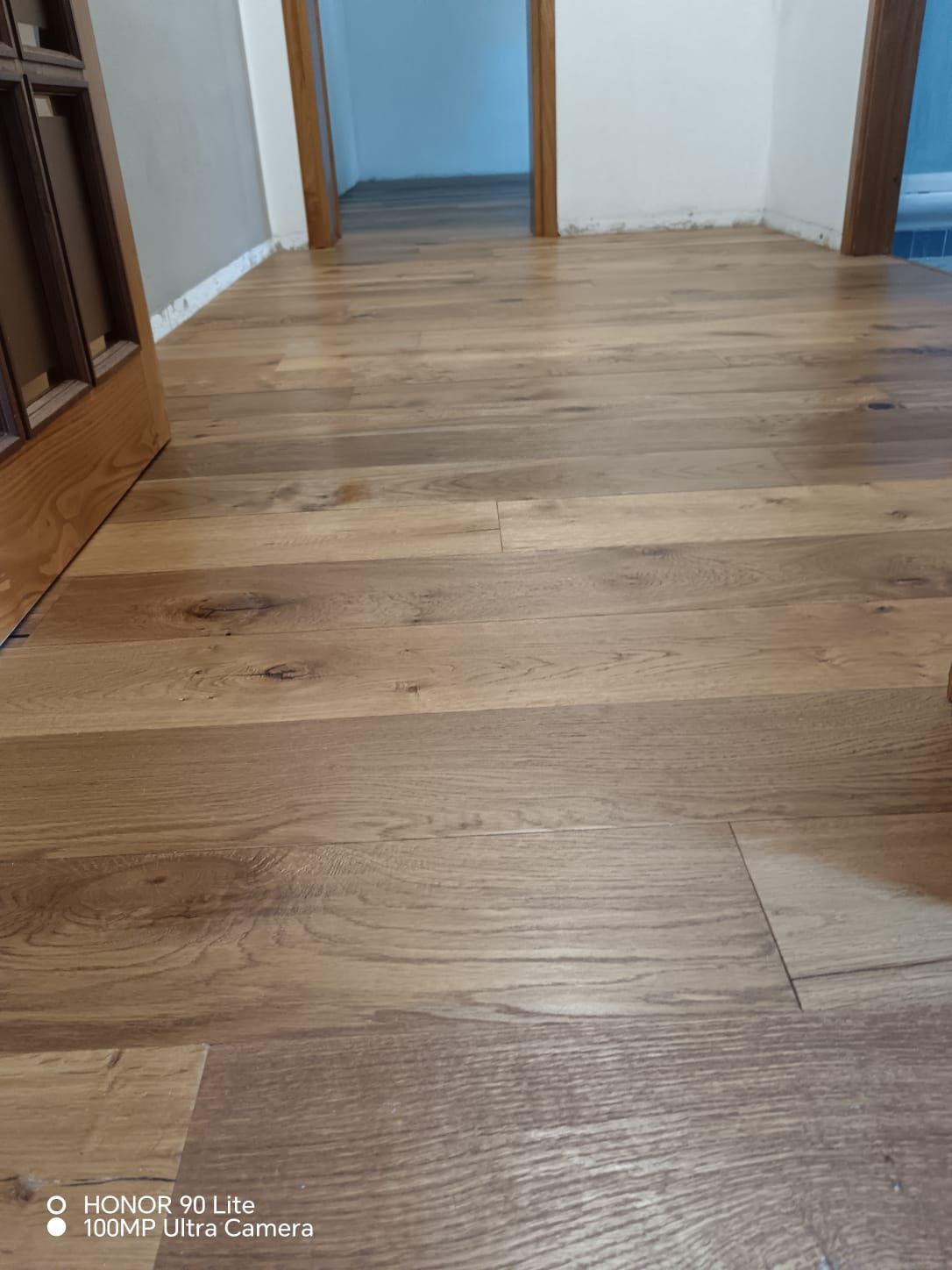 Pavimento in legno di un corridoio che conduce a porte aperte all’interno di un’abitazione