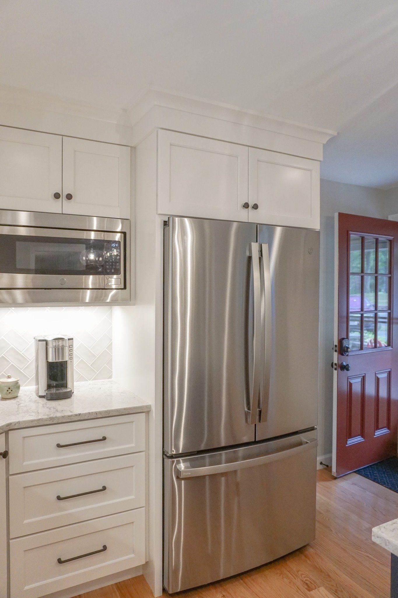 A kitchen with a stainless steel refrigerator and microwave.