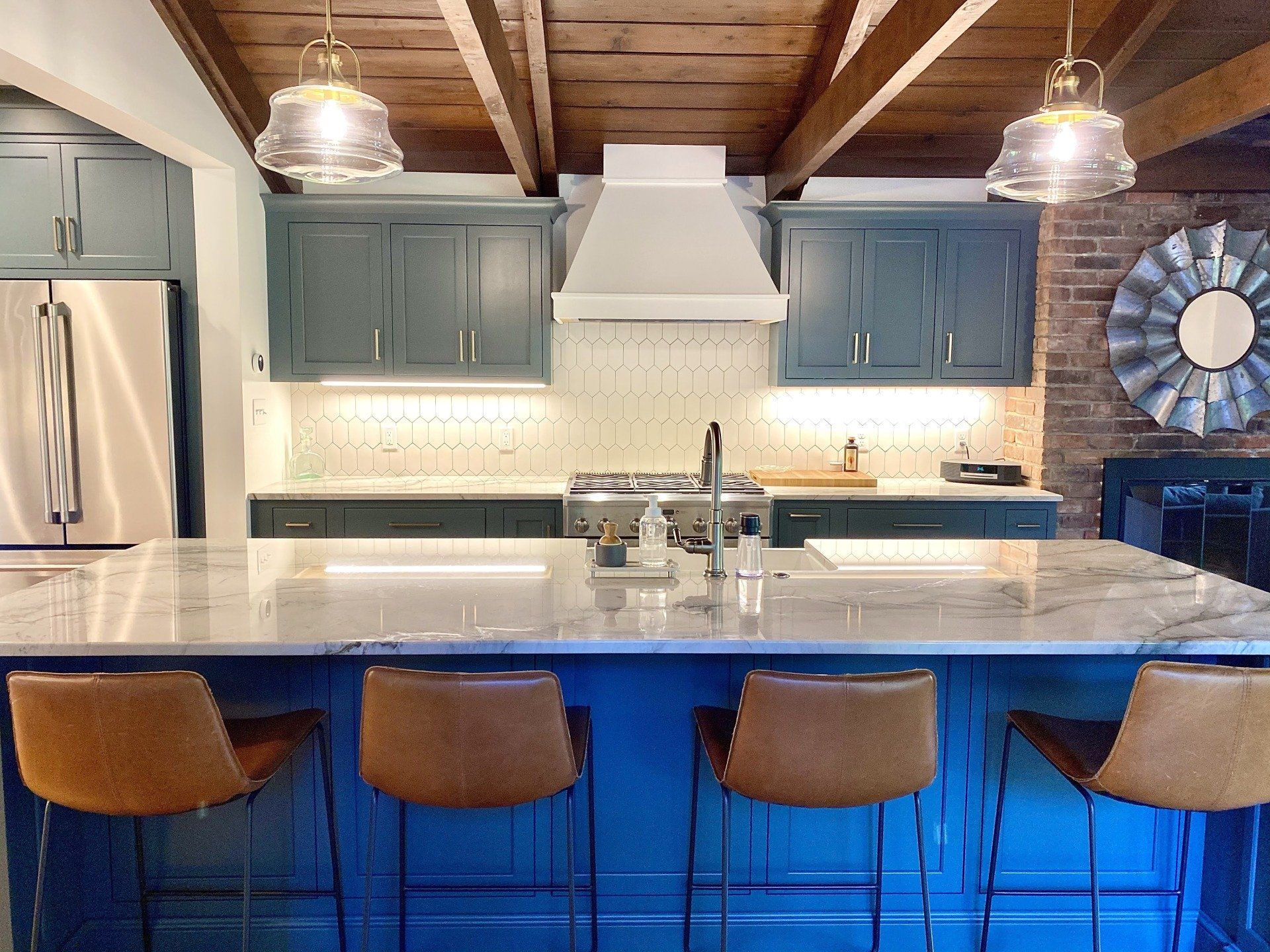 A kitchen with blue cabinets and a large island