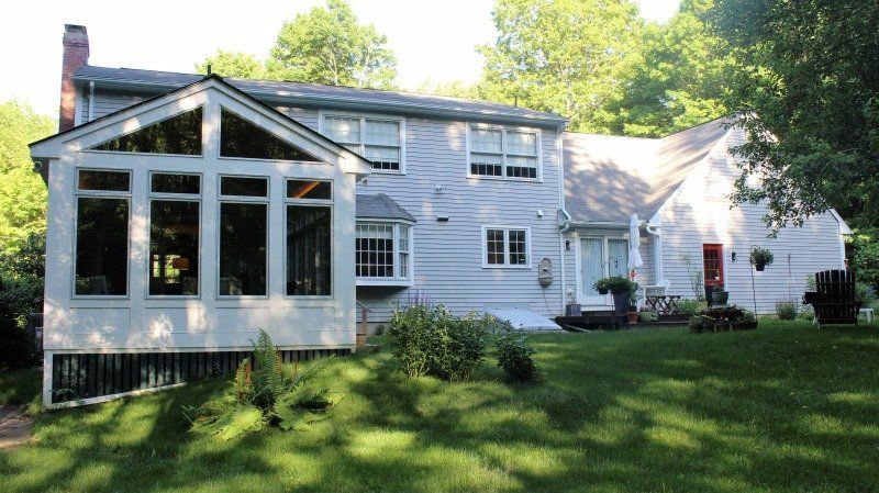 A large white house with a large screened in porch addition in Western MA
