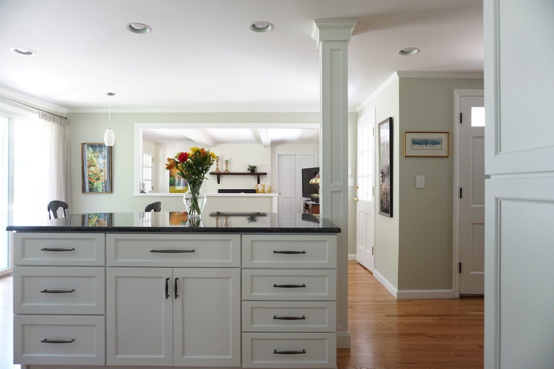 A kitchen with white cabinets and black counter tops
