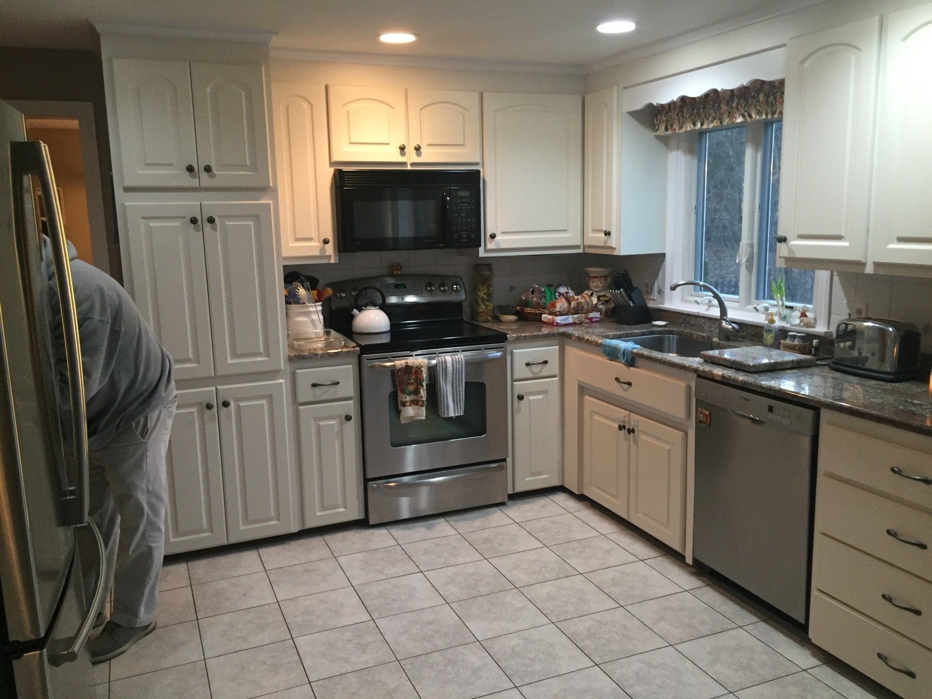 A kitchen with white cabinets and stainless steel appliances
